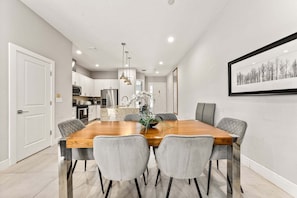A modern kitchen with white cabinets, a stainless steel refrigerator, and a central island. - Ultra Convenient Stay > 5 min to Disney (Kissimmee)