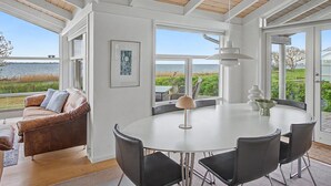 Ein geräumiges Zimmer mit einem großen runden Tisch, einem Ledersofa und Meerblick.