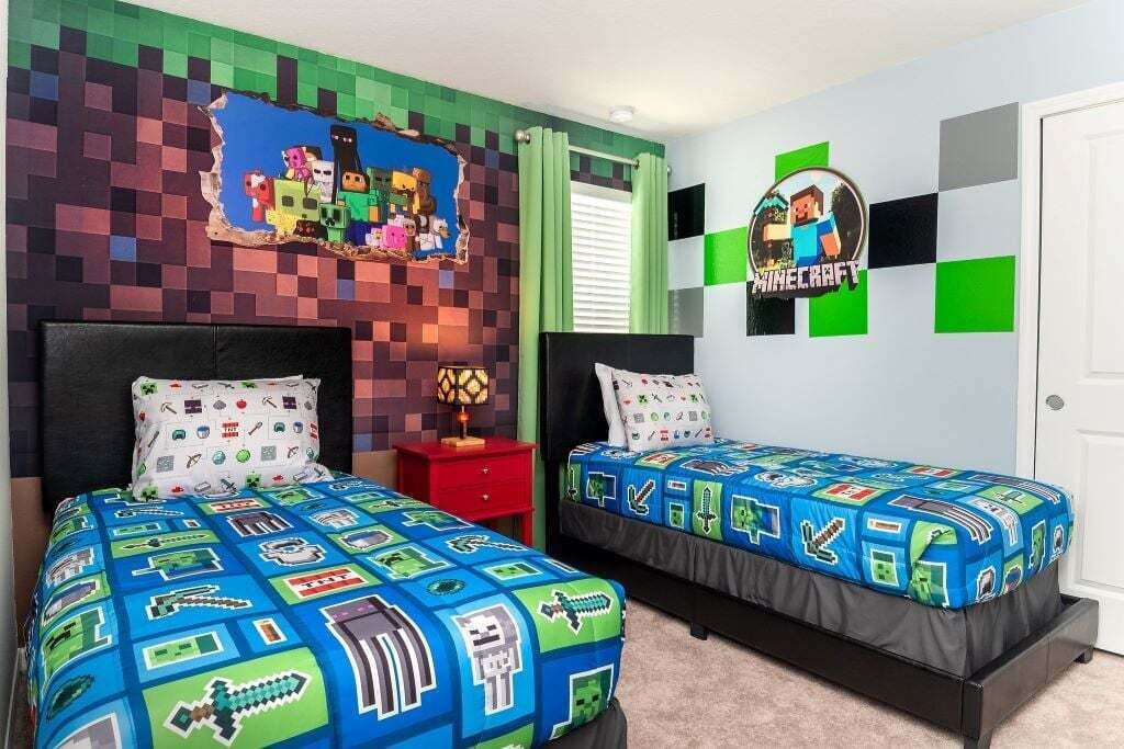 A bedroom with two beds, a wall mural, and a Minecraft-themed wall decoration.