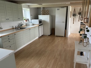 A kitchen with light-colored cabinets, a microwave, a refrigerator, and a sink. - "Jorek" - 700m from the sea by Interhome (Lemvig)