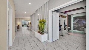 Een hotelgangen met een modern design, met een marmeren vloer, een receptiegedeelte met een 'WARS' thema decor en een zithoek met uitzicht.