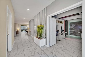 Ein Hotelkorridor mit modernem Design, Marmorboden, einer Rezeption mit WARS-Thema und einer Sitzecke mit Blick.