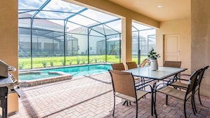 A patio area with a pool, outdoor seating, and a view through a glass enclosure. - Fantastic Home at Solterra Sol102 (Davenport)