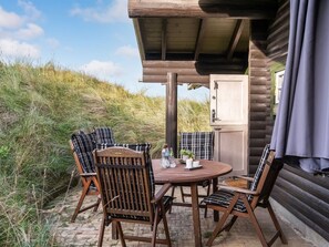 A wooden outdoor seating area with a table and chairs, surrounded by natural landscape. - "Apelone" - 450m from the sea by Interhome (Blokhus)