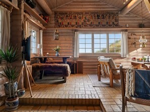 A log cabin interior with a fireplace, wooden furniture, and a large window. - "Apelone" - 450m from the sea by Interhome (Blokhus)