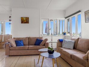 A living room with a beige sofa, a small round table, and a window with a view. - "Elodie" - 10m from the sea by Interhome (Bjert)