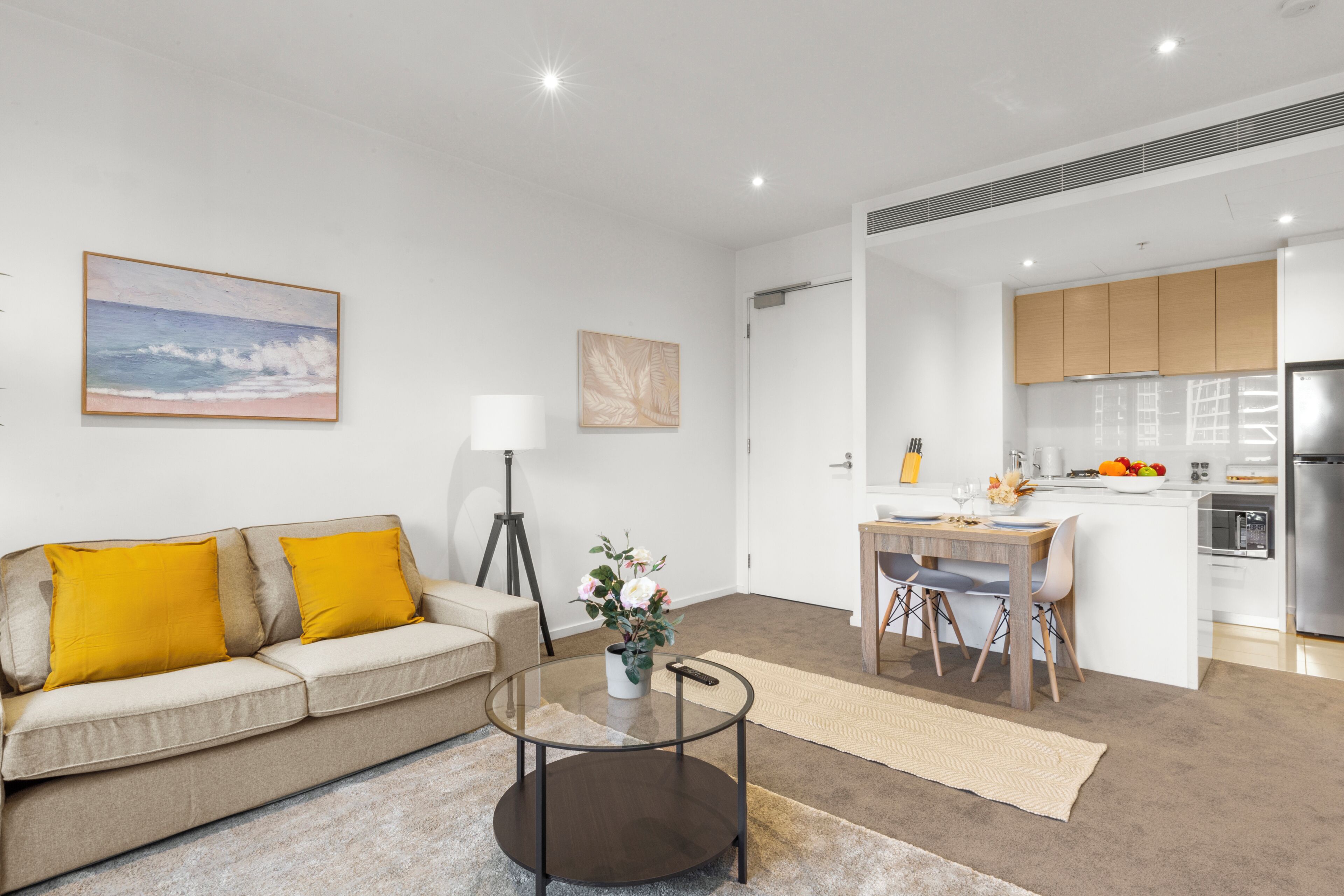 A modern apartment with a living room, dining area, and kitchen.
