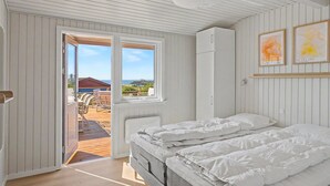 A bedroom with a bed, a wardrobe, and a view of the outdoors. - "Teofan" - 325m from the sea by Interhome (Ebberup)