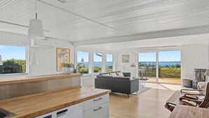 A spacious living area with a wooden dining table, a sofa, and a kitchen area with a wooden countertop and white cabinets. - "Teofan" - 325m from the sea by Interhome (Ebberup)