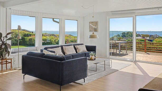 A modern living room with a dark blue sofa, large windows, and a view of the outdoors. - "Teofan" - 325m from the sea by Interhome (Ebberup)