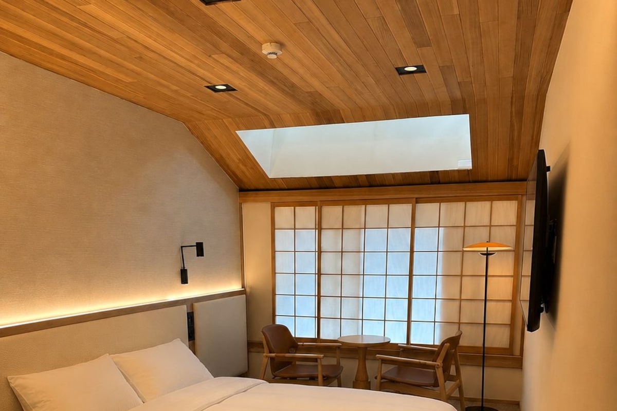 A modern bedroom with a bed, a desk, and a chair.