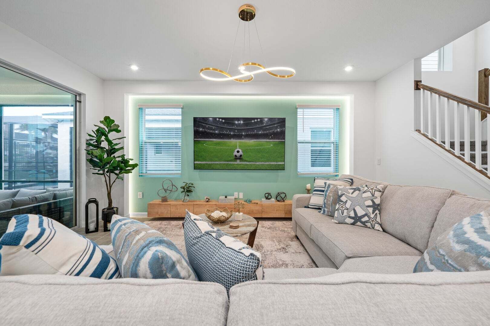 A modern living room with a large TV, a sofa, and a coffee table.