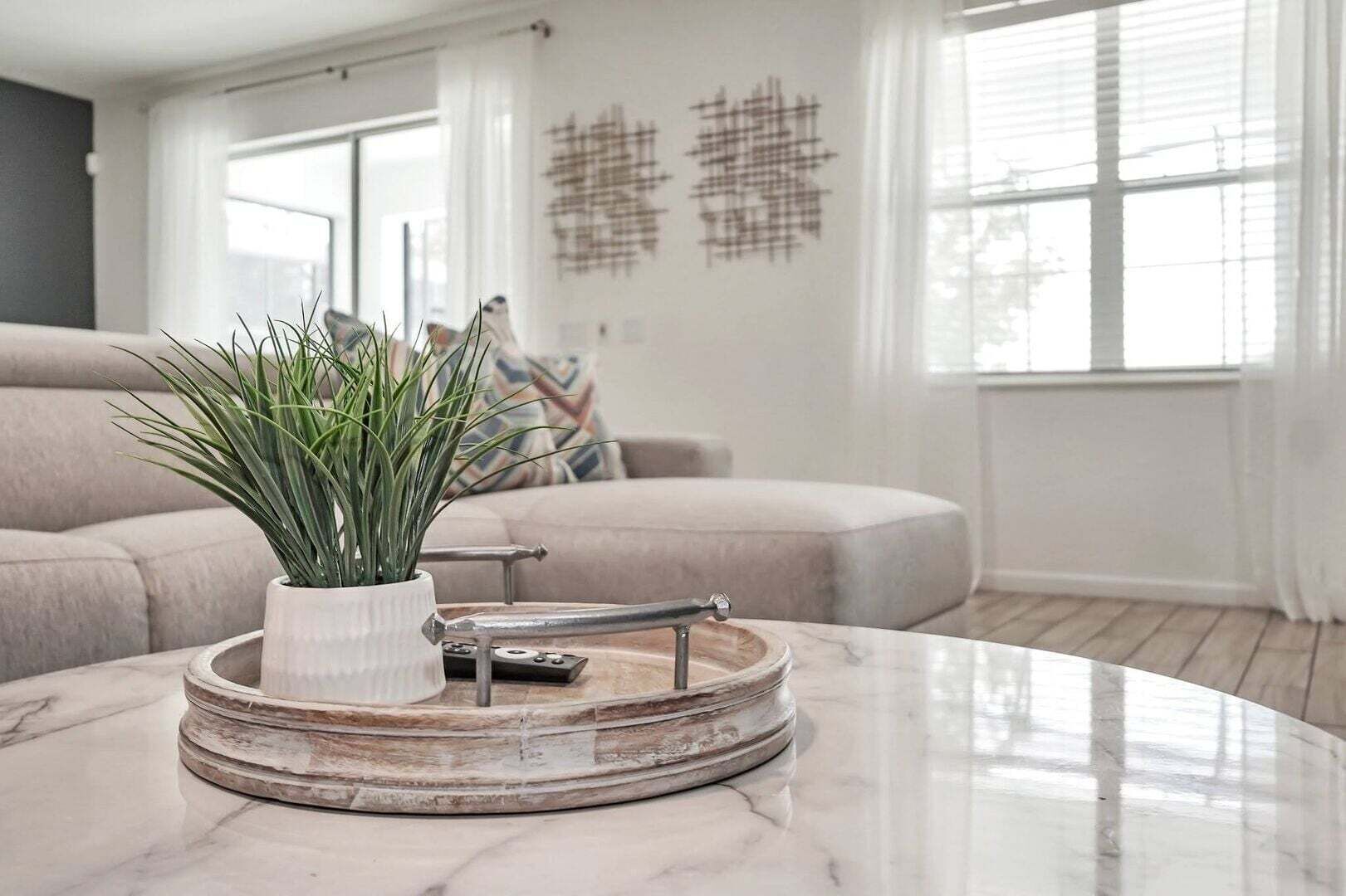 Una sala de estar moderna con una mesa de centro de mármol, una planta en maceta y una decoración minimalista.