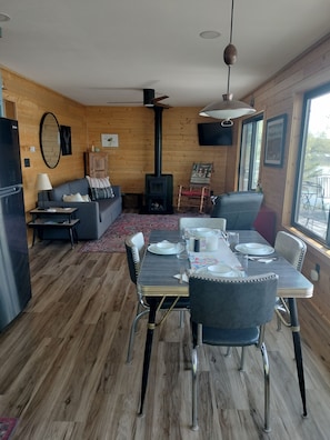 Ein modernes Interieur mit Essbereich, Sofa, Kamin und großen Fenstern.
