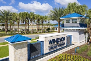 A sign for the Windsor Island Resort with a blue roof and a white building. - Modern Vacation Home 5 BR, 4.5 BA Villa Sleeps 12! (Davenport)