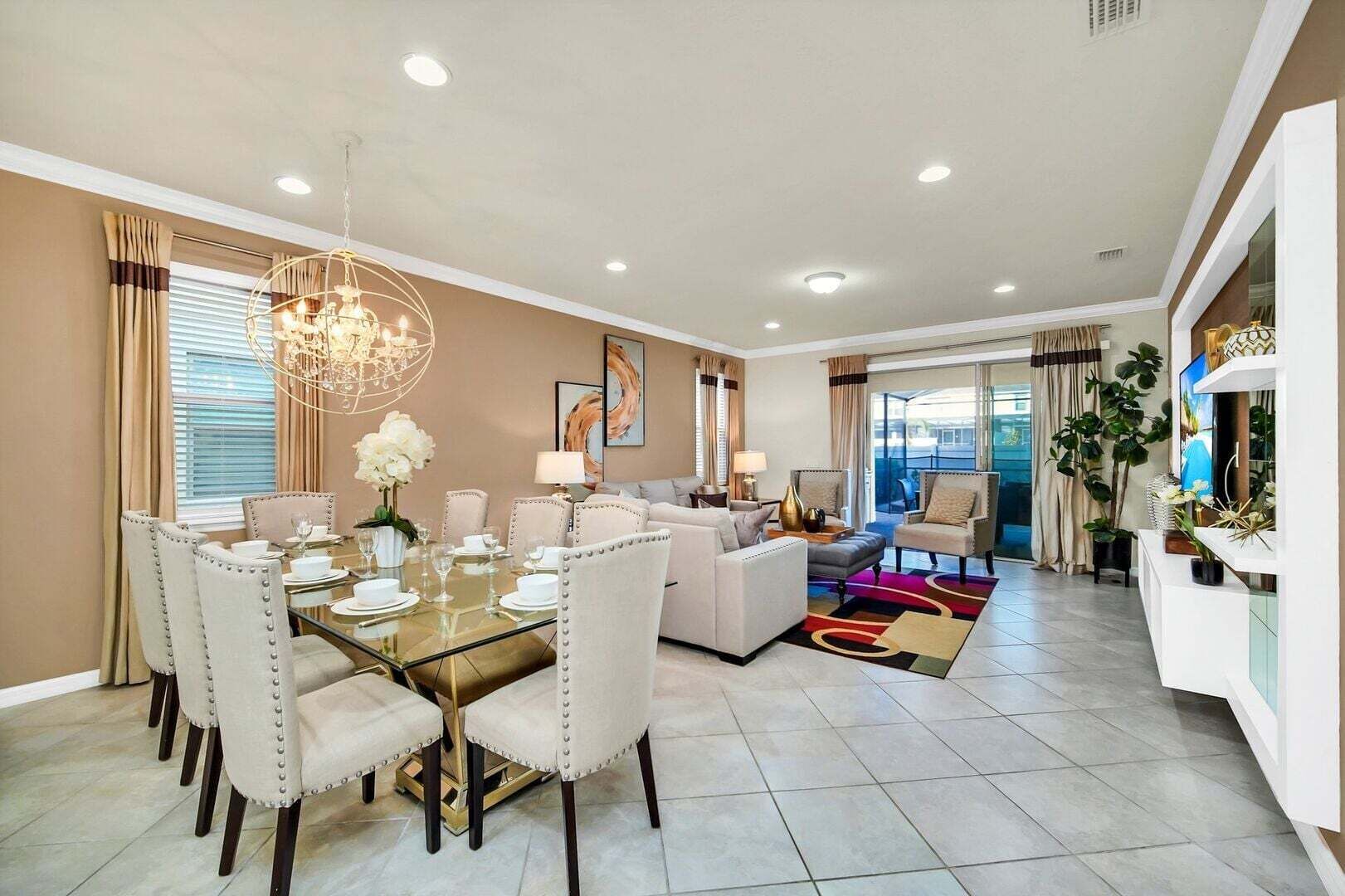 A modern hotel room with a dining area, a living room, and a balcony with a view.