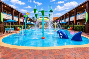 Ein Wasserpark mit zahlreichen Wasserelementen, darunter Springbrunnen und Wasserrutschen, umgeben von einem Pool.