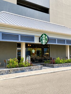 A Starbucks with a modern design, outdoor seating, and a clear storefront. - PRICE DROP! 2BR Resort Villa, Pool, Splash Pad, Gym & Shuttle. Great for family. (Cocoa Beach)