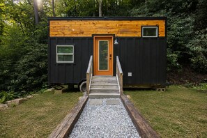 Una petita cabana amb una porta de fusta, una finestra i una rampa que condueix a l'entrada.
