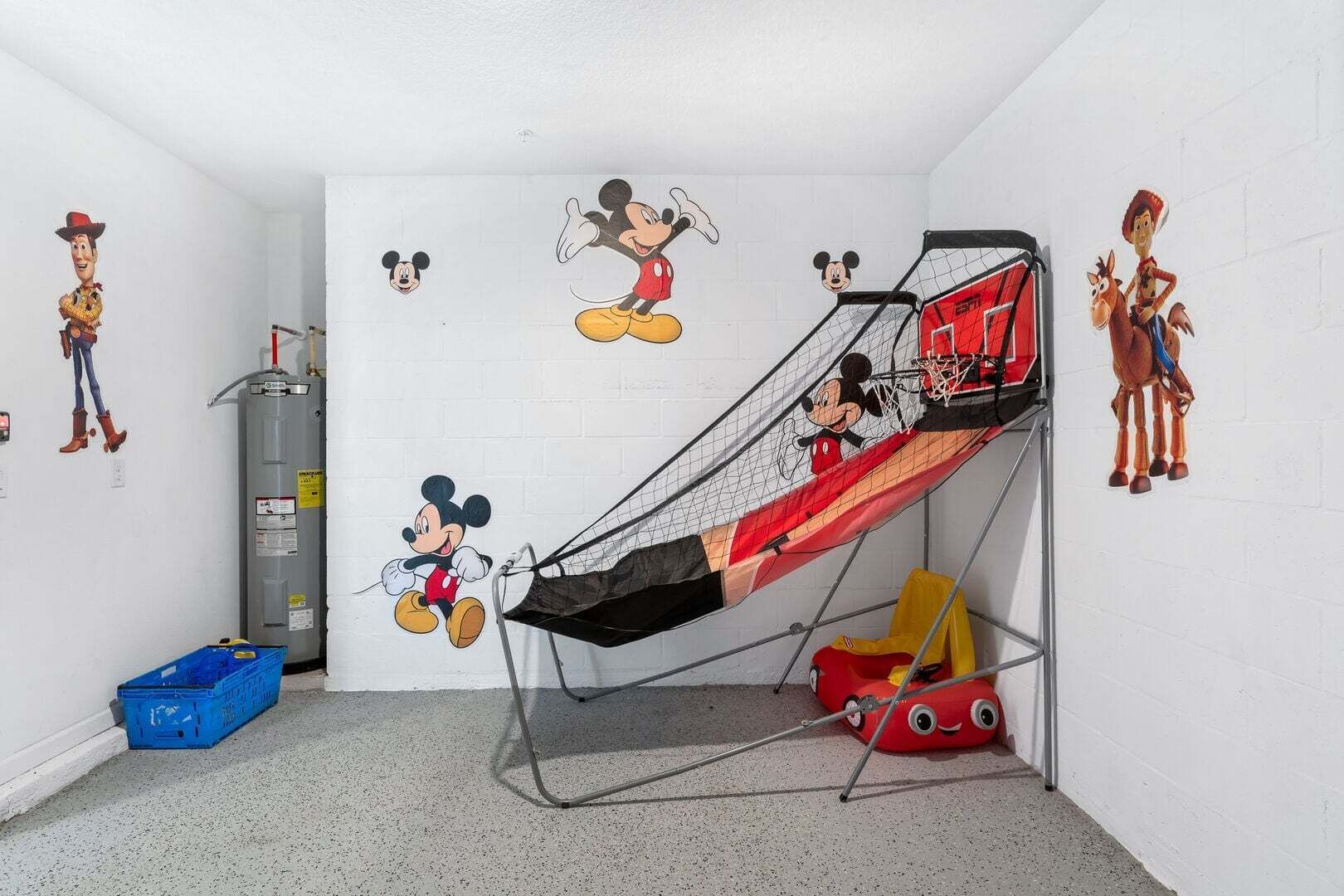 A room with a bunk bed, Mickey Mouse and Woody wall decals, a water heater, and a red toy car.