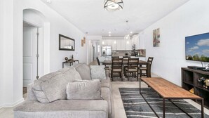 A modern living room with a sofa, dining table, and TV. - Free Water Park Walking Distance! (Davenport)
