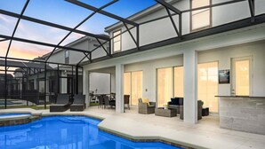 An indoor pool with a glass ceiling, outdoor seating, and a poolside bar. - Spacious 9br, 9BA Resort Home w/ Private Pool (Kissimmee)