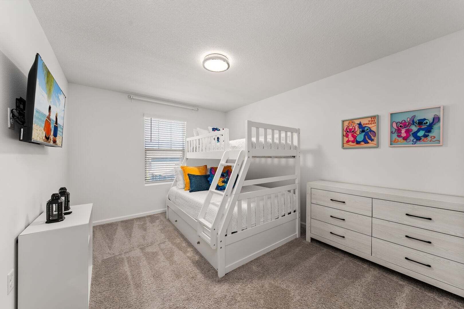 Habitación infantil con literas, cómoda y decoración en la pared.
