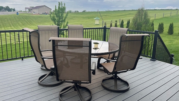 A deck with outdoor furniture, a table, and chairs. - Spacious 4-bedroom home in a beautiful neighborhood on the edge of town (Dubuque)