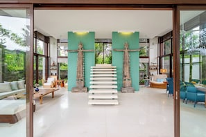 Un interior moderno con una escalera, zonas de estar y elementos decorativos.