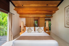 Un dormitorio con una cama grande, techo de madera y vistas a la vegetación exterior.