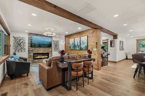 A spacious living area with a fireplace, a dining area, and a kitchen. - New • Luxury • Location • Theater • 4decks • Views (Gatlinburg)
