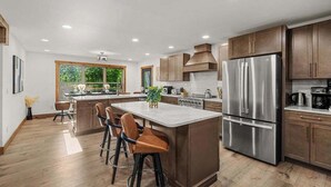 Una cucina moderna con isola centrale, elettrodomestici in acciaio inossidabile e mobili in legno.