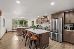 A modern kitchen with a central island, stainless steel appliances, and wooden cabinetry. - New • Luxury • Location • Theater • 4decks • Views (Gatlinburg)