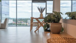 A modern interior with a large window, a wooden table, and a potted plant.