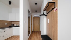 Une cuisine moderne avec des meubles blancs, un plancher en bois et un banc noir.
