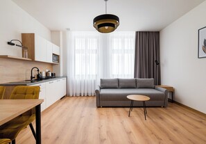 Ein moderner Wohnraum mit Sofa, Esstisch und Küchenzeile.