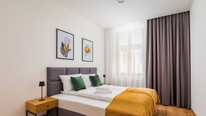 Une chambre à coucher moderne, avec un lit, des tables de chevet et des œuvres d’art accrochées au mur.
