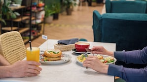 Un comedor con una mesa, sillas, una cesta y platos de comida.