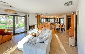 Ein modernes Wohnzimmer mit einer Couch, einem Essbereich und einem Kamin.