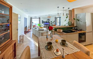 Eine moderne Küche mit Essbereich, Holzboden und Blick zum Wohnzimmer.