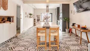A modern kitchen with a central island, pendant lighting, and patterned flooring.