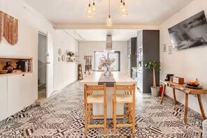 A modern kitchen with a central island, pendant lighting, and patterned flooring.