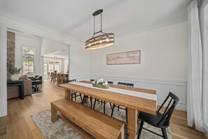 A dining area with a wooden table, benches, and chairs. - Luxury Golf & Ski Retreat - Owl's Nest (Campton)