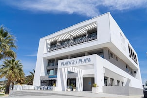 Un edificio moderno con techo plano y un cartel que dice 'PLATA'.