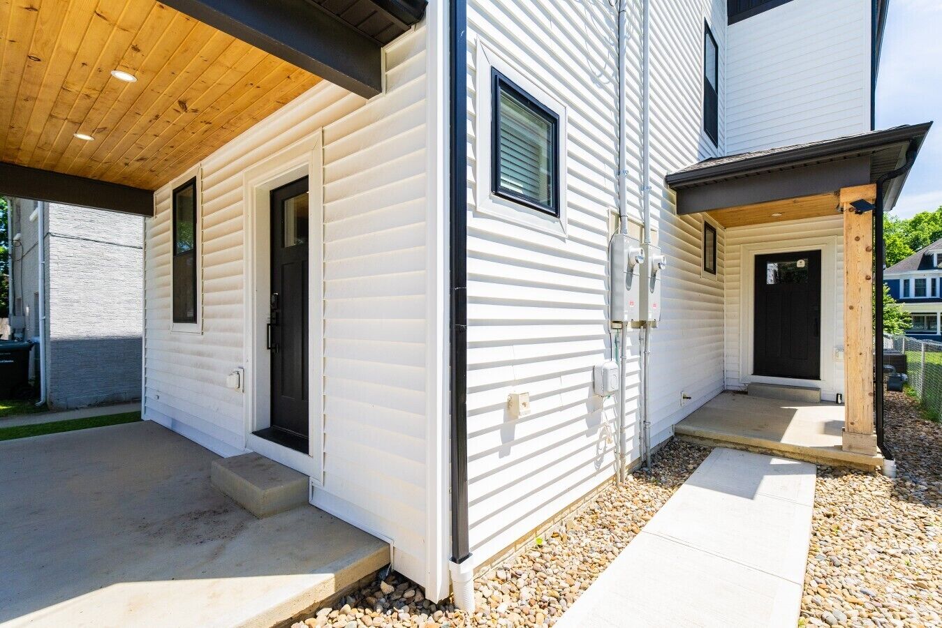 A two-story house with a covered patio, a front door, and a small porch.