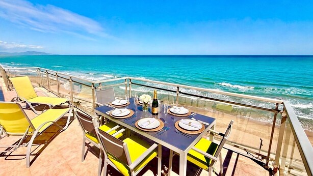 A table set for dining with a view of the ocean.