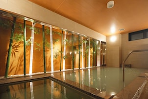 A swimming pool with glass walls and bamboo plants.