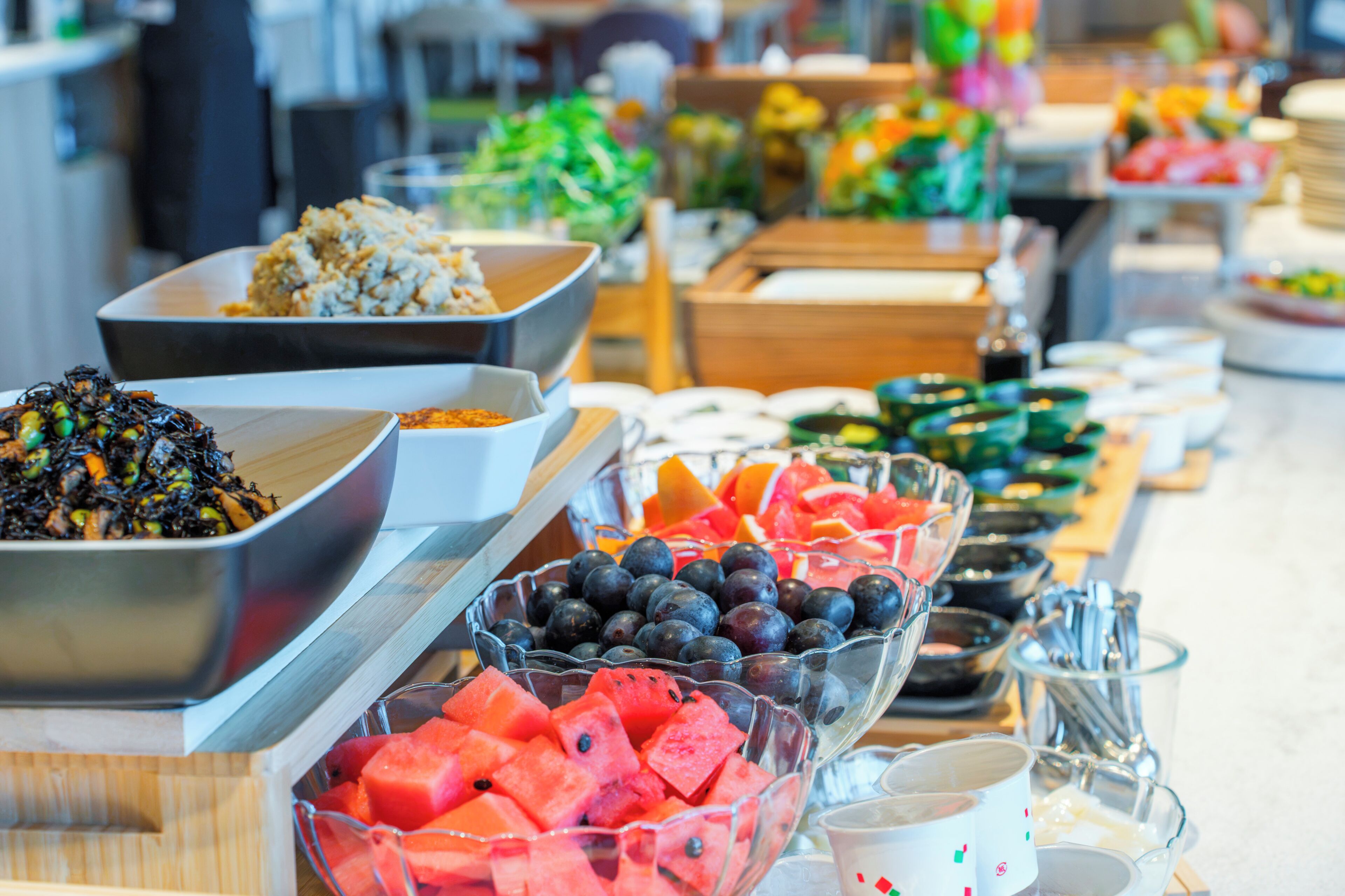 A buffet with various food items including fruits, vegetables, and grains.