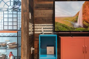 Ein Zimmer mit Fernseher, der einen Wasserfall zeigt, einer blauen Ablage und Holzverkleidung.