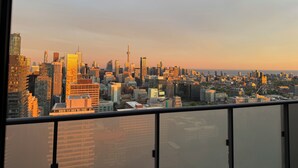 A cityscape view from a high-rise building with a variety of buildings, including a prominent tower. - Sunset Skyline Corner Suite in Downtown Toronto with Stunning CN Tower View! (Toronto)